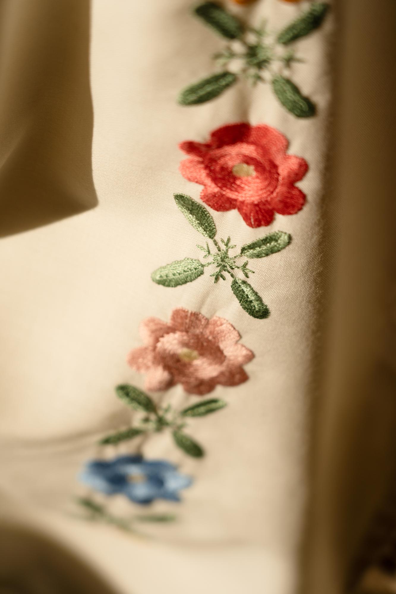 Nahaufnahme eines handgestickten Blumendetails auf Leinen